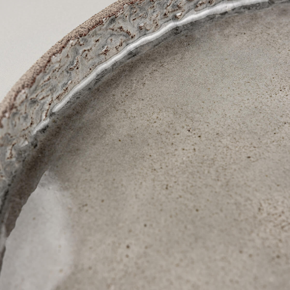 Natural stoneware texture under glossy finish on a refined ceramic dinner plate.