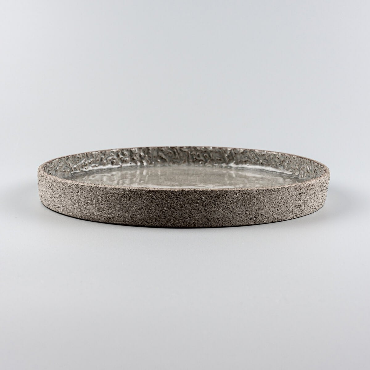 Side view of luxury ceramic dinner plate with straight vertical edge for fine dining presentation.