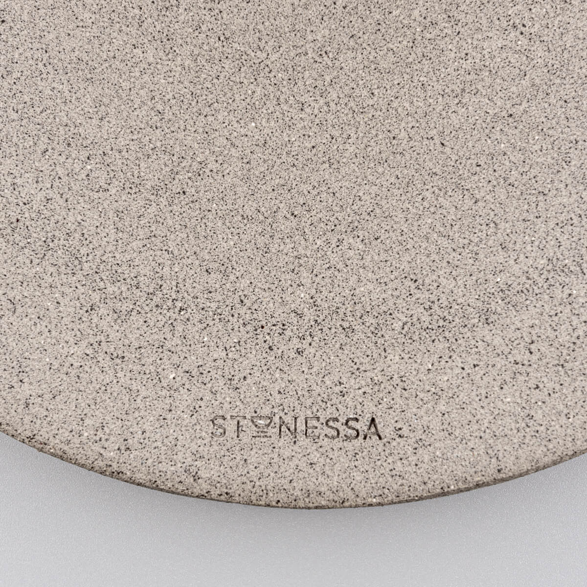 Bottom of unglazed dark stoneware showing handmade craftsmanship and raw finish.