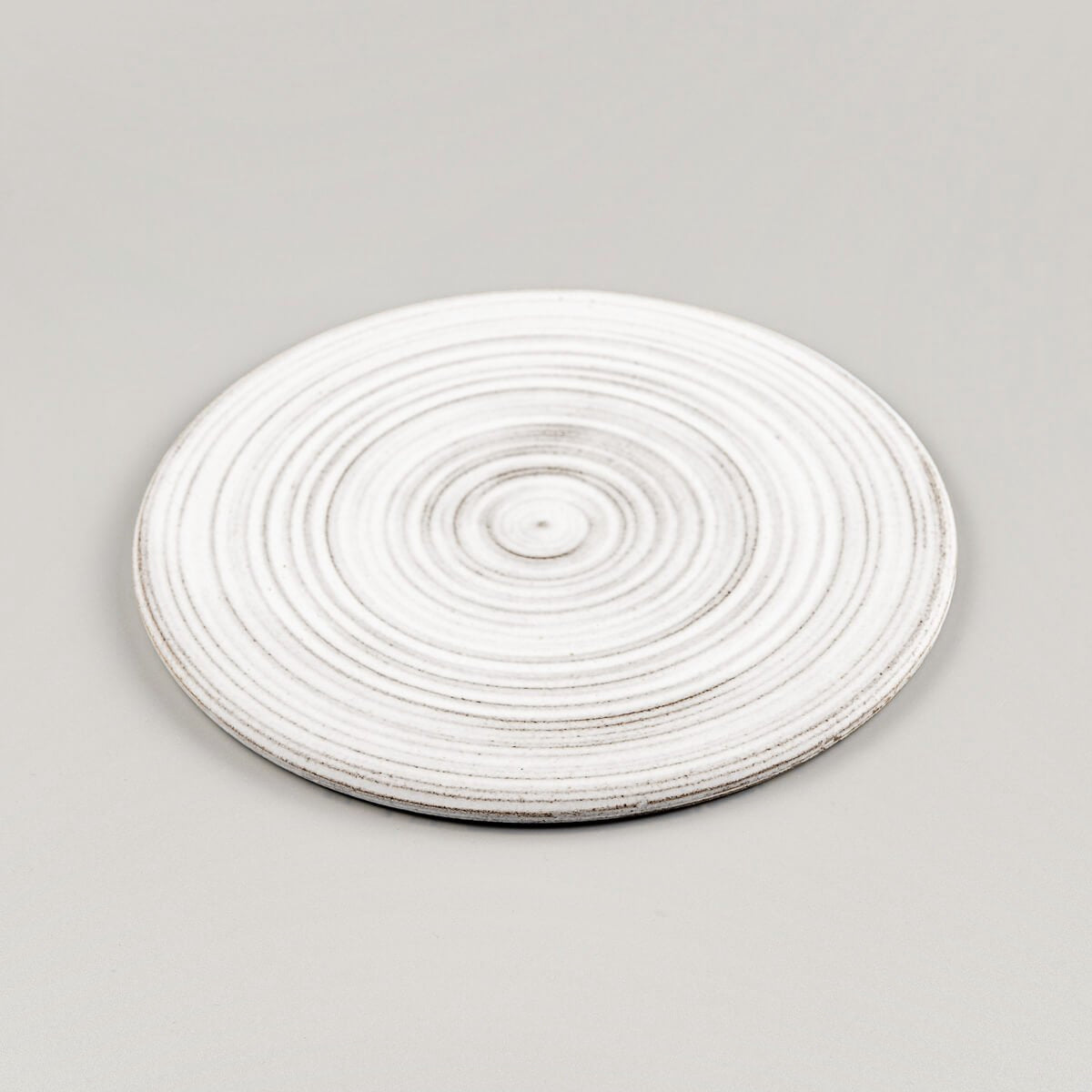 Minimalist white ceramic plate handcrafted from stoneware clay for culinary plating.