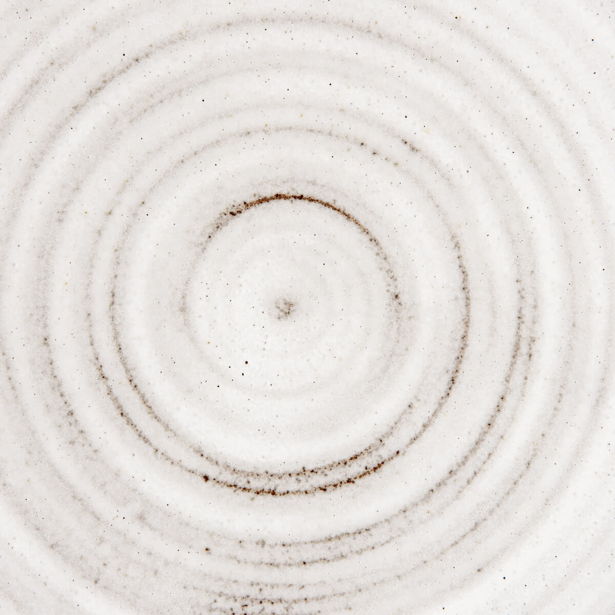 Close-up of concentric ridged surface on handmade ceramic plate for premium chefs.