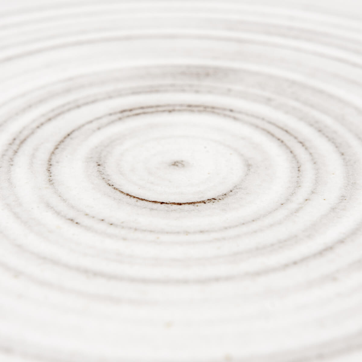 Set of minimalist flat ceramic plates stacked for space-saving kitchen storage.