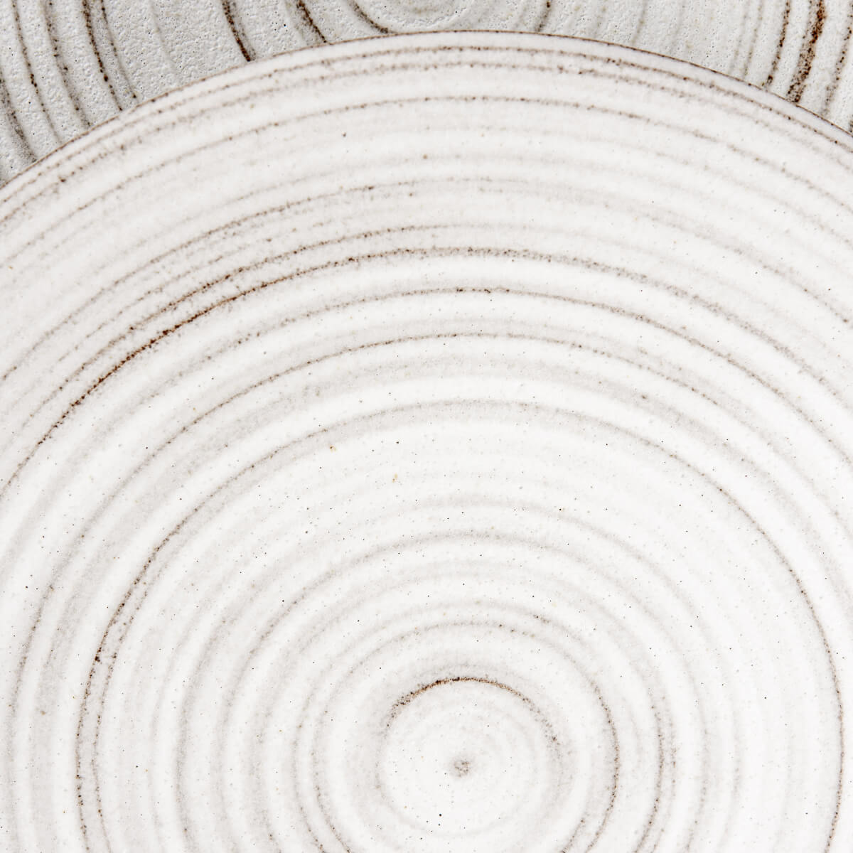 Stacked ceramic plates showing raw unglazed undersides and natural textures.