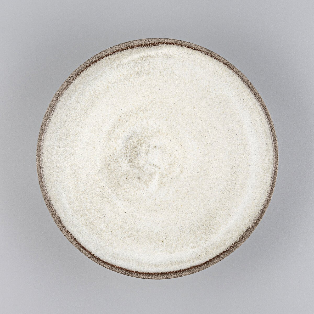Handmade ceramic plate with minimalist design and matte white glaze for culinary presentation.
