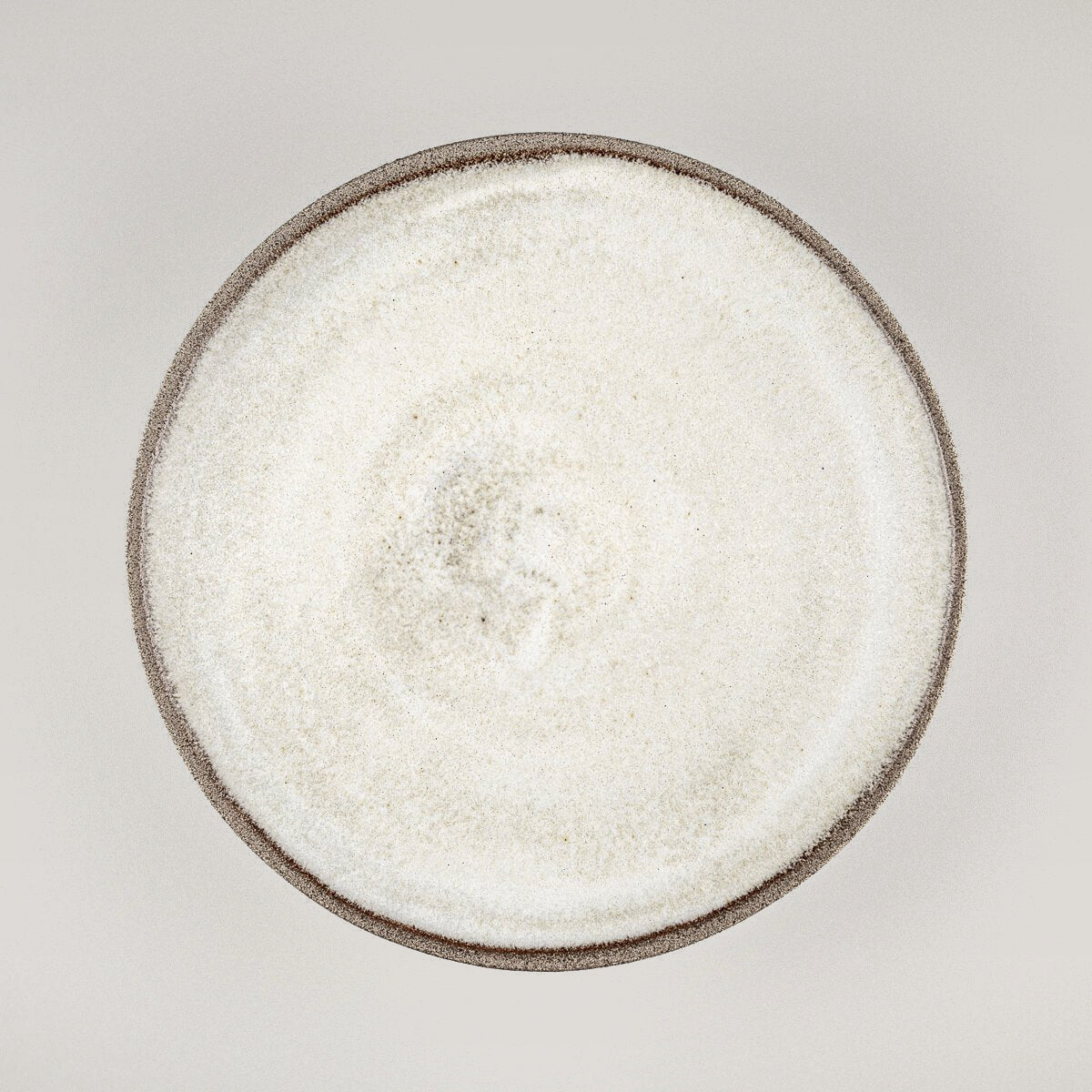 Handmade ceramic plate with minimalist design and matte white glaze for culinary presentation.