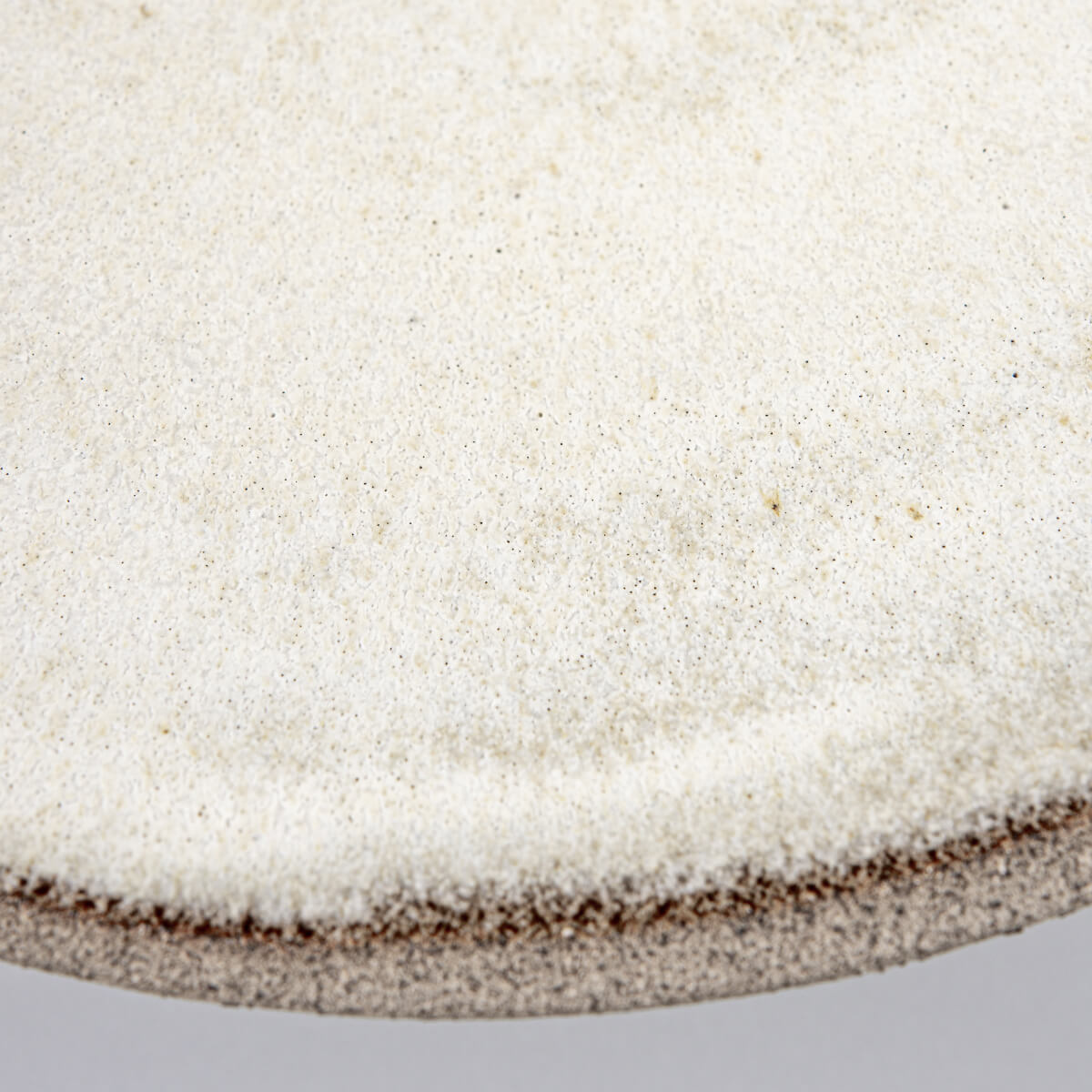 Close-up of edge revealing fine texture contrast between glazed interior and raw exterior.