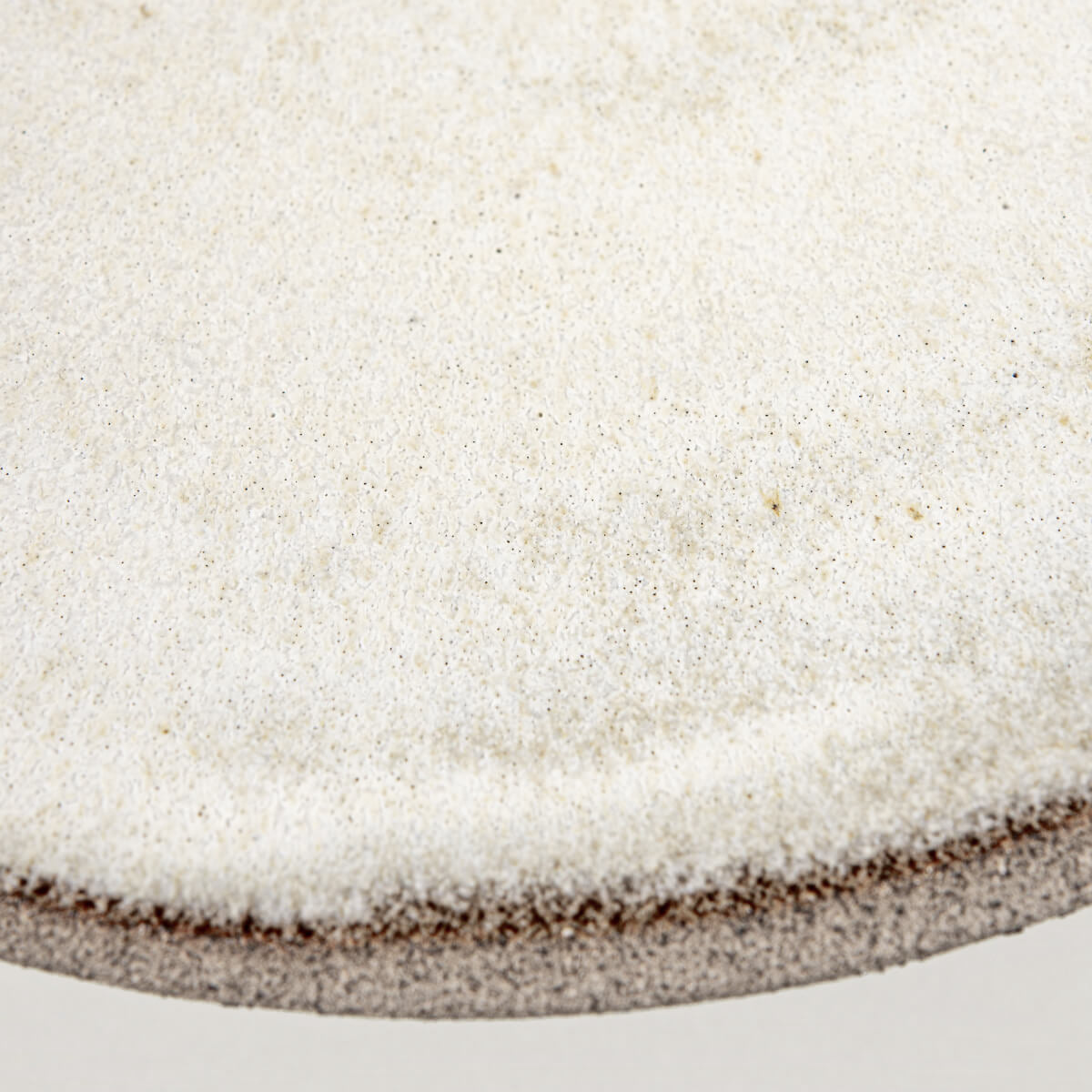 Close-up of edge revealing fine texture contrast between glazed interior and raw exterior.