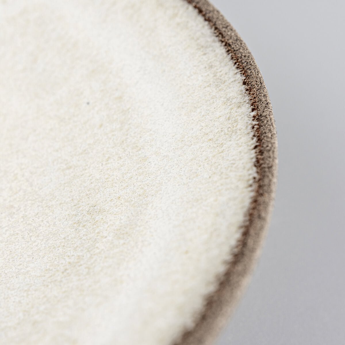 Detail of handmade ceramic craftsmanship with focus on edge precision.
