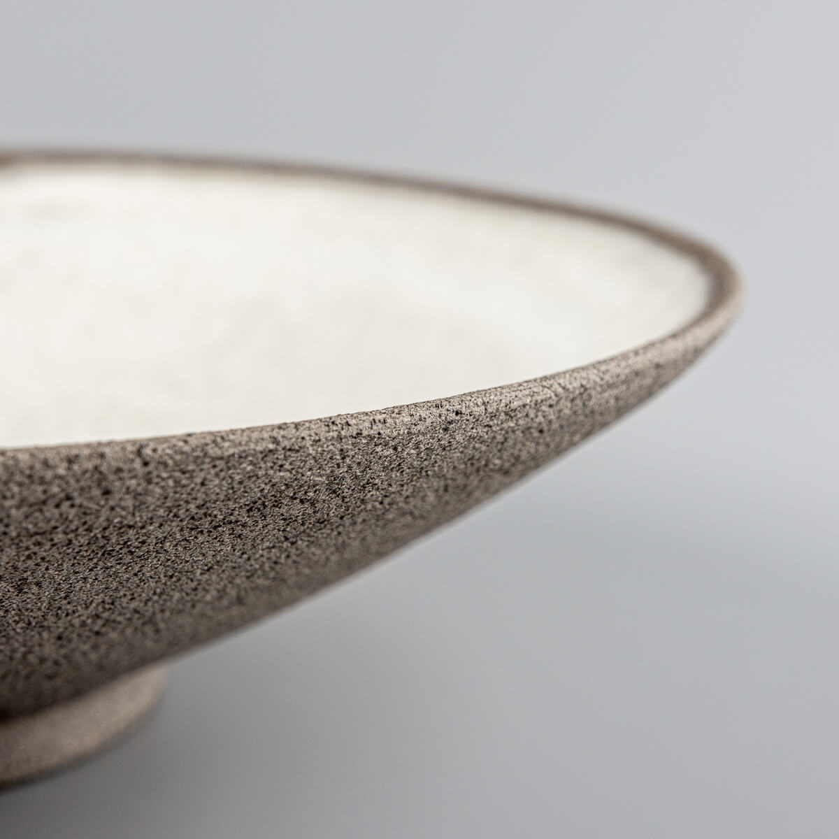 Fine dining plate with matte glaze and rustic clay base for unique serving moments.