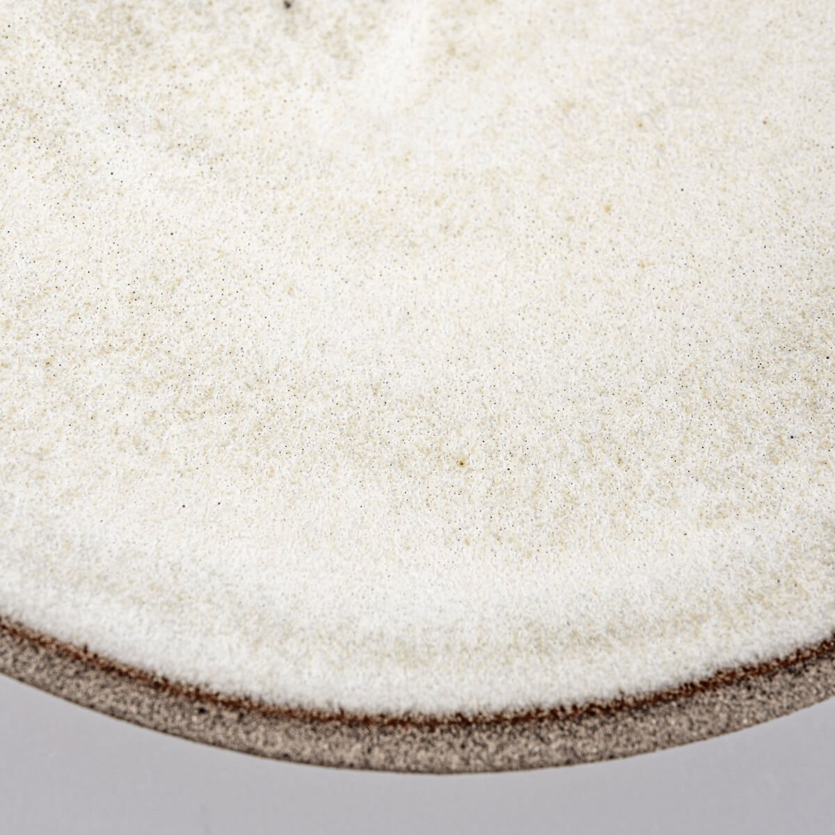 Angular view of modern ceramic plate highlighting contrast between surfaces.