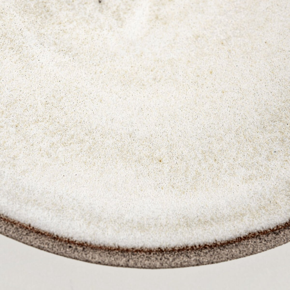 Angular view of modern ceramic plate highlighting contrast between surfaces.