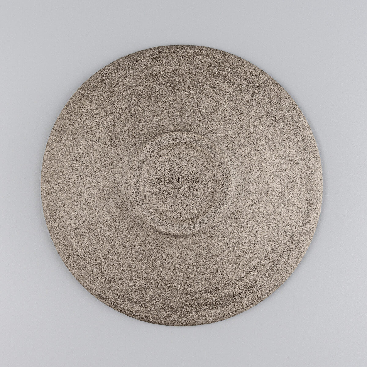 Base view of artisanal ceramic plate showing spiral potter’s wheel marks.