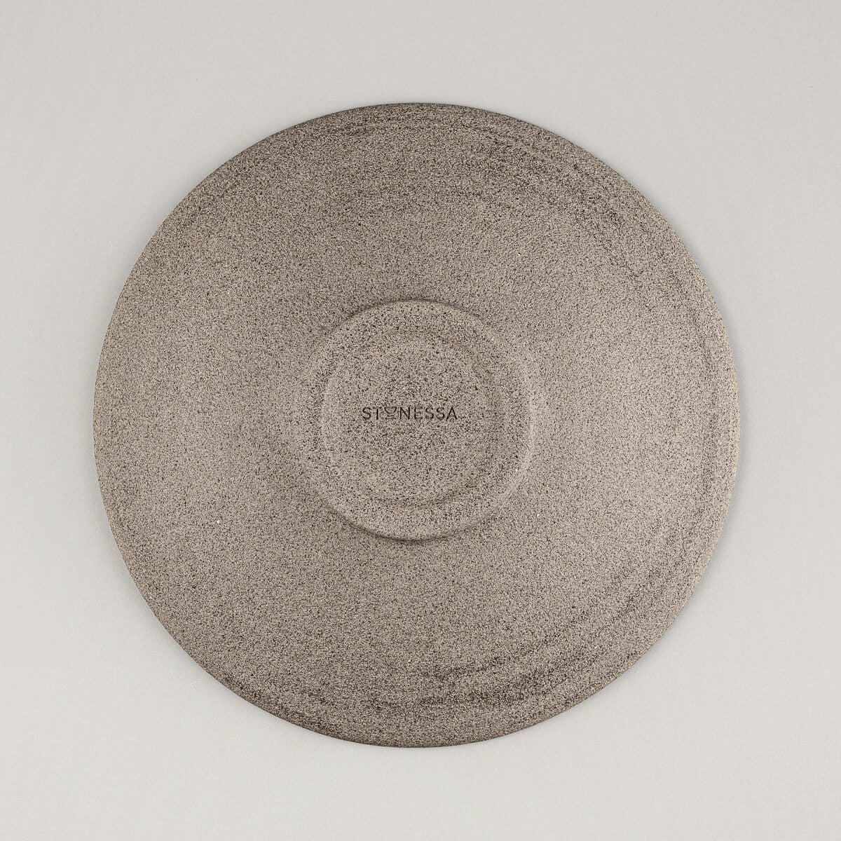 Base view of artisanal ceramic plate showing spiral potter’s wheel marks.