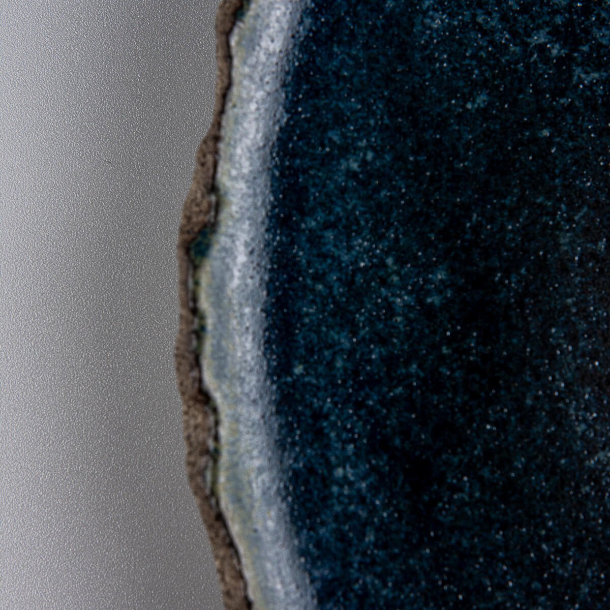 Close-up of handcrafted blue ceramic glaze with subtle texture, perfect for luxury culinary presentation.