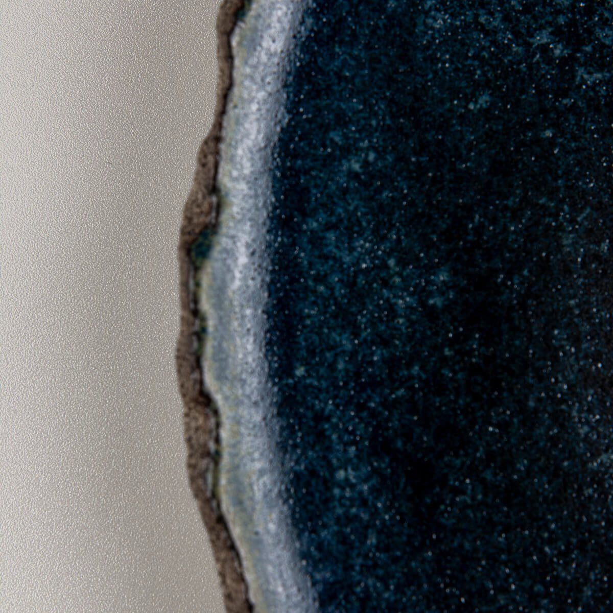 Close-up of handcrafted blue ceramic glaze with subtle texture, perfect for luxury culinary presentation.