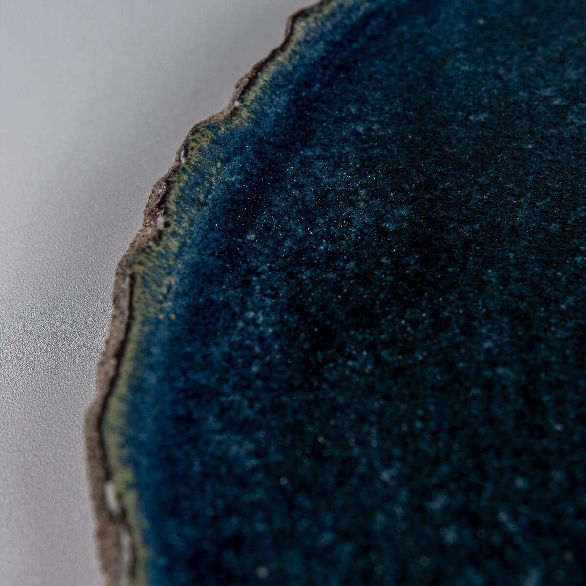 Surface texture of blue ceramic plate designed for refined dessert plating in restaurants or hotels.