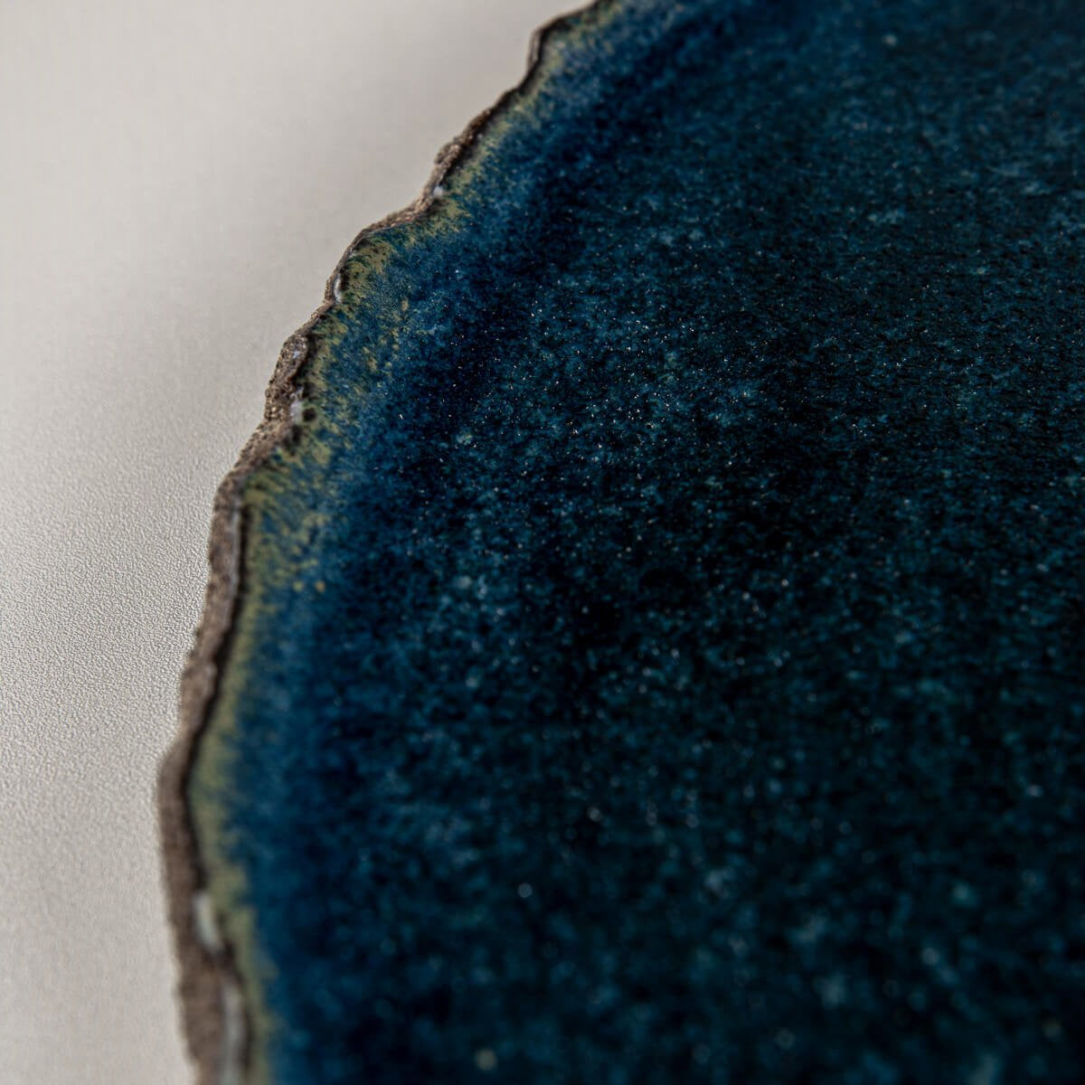 Surface texture of blue ceramic plate designed for refined dessert plating in restaurants or hotels.
