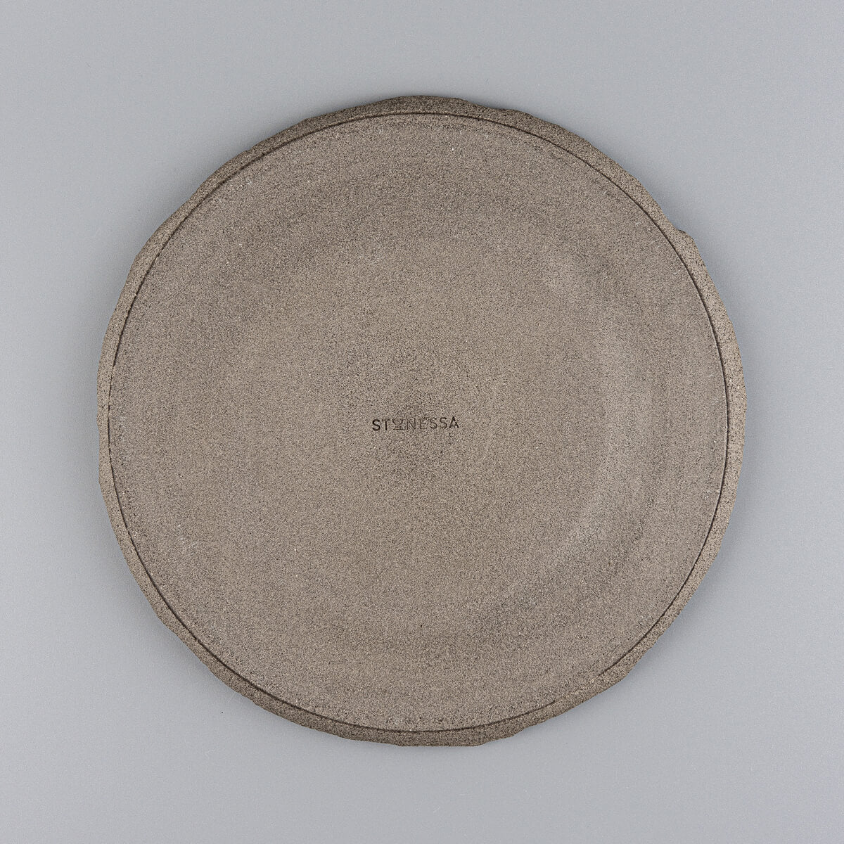 Underside of unglazed stoneware plate revealing raw ceramic finish for rustic-modern kitchenware appeal.