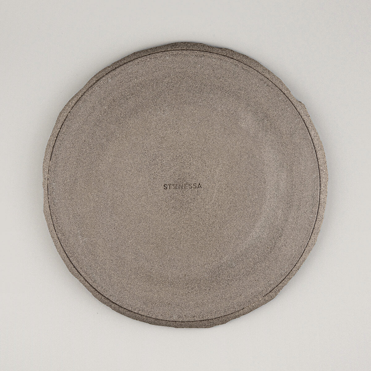 Underside of unglazed stoneware plate revealing raw ceramic finish for rustic-modern kitchenware appeal.