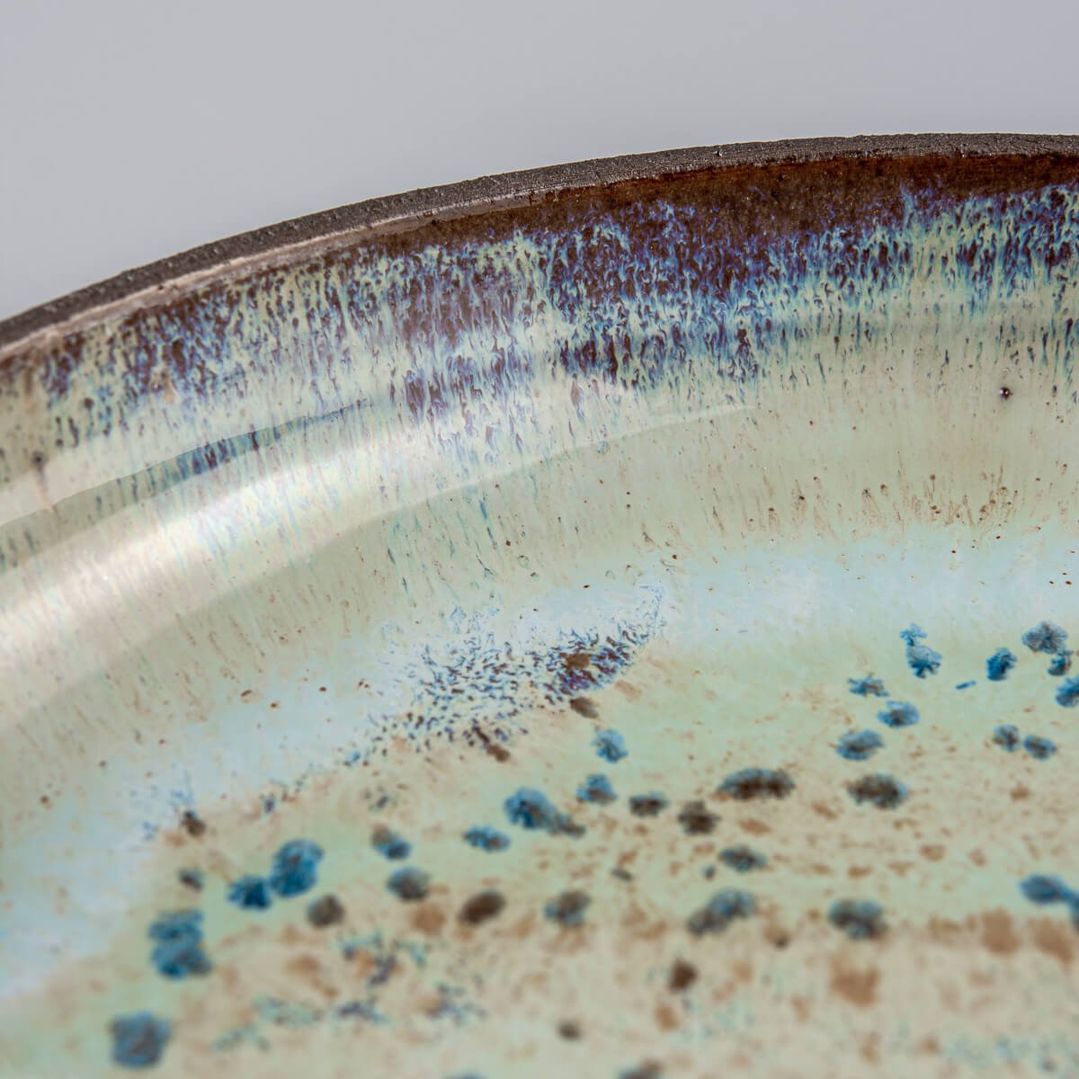Detail of unique speckled glaze on handcrafted ceramic tableware.