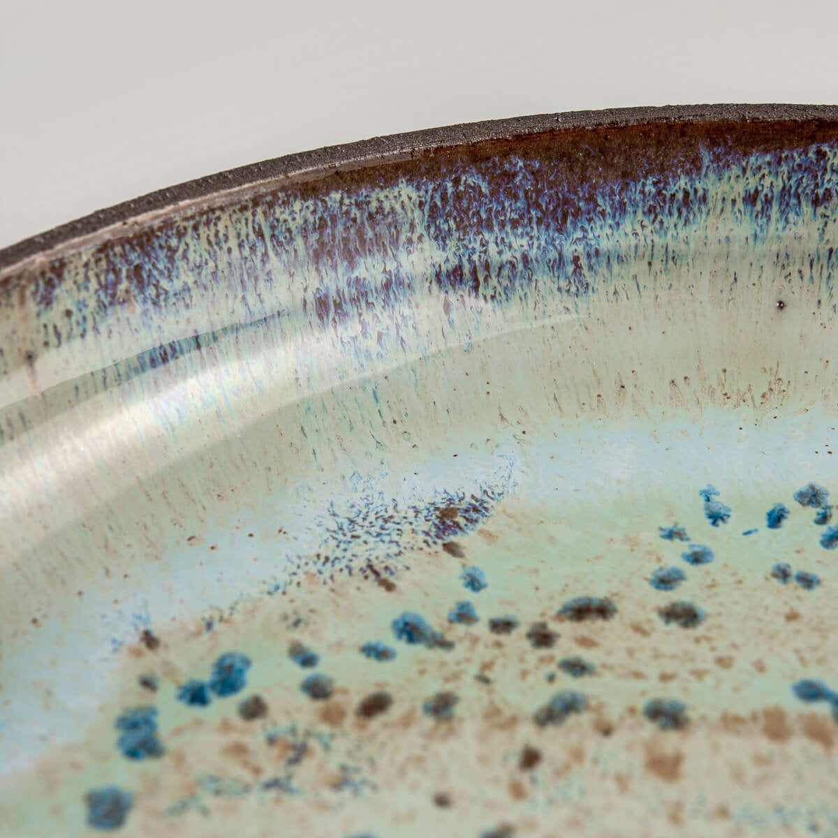 Detail of unique speckled glaze on handcrafted ceramic tableware.