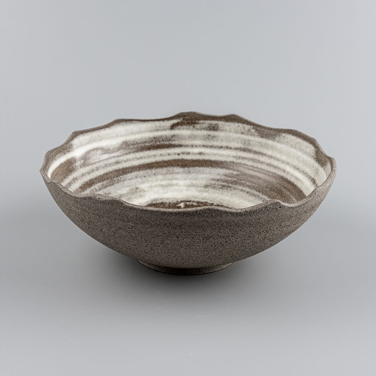 Handcrafted stoneware bowl with sculpted chipped edges and matte white glaze for home or restaurant use.