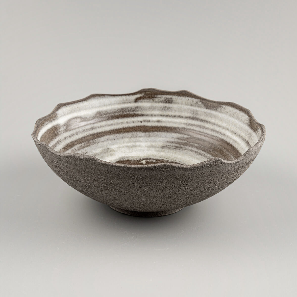 Handcrafted stoneware bowl with sculpted chipped edges and matte white glaze for home or restaurant use.
