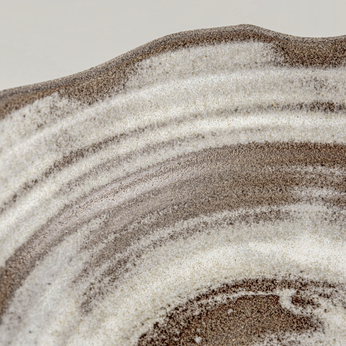 Close-up of textured glaze and chipped-edge detailing on handcrafted pottery bowl.