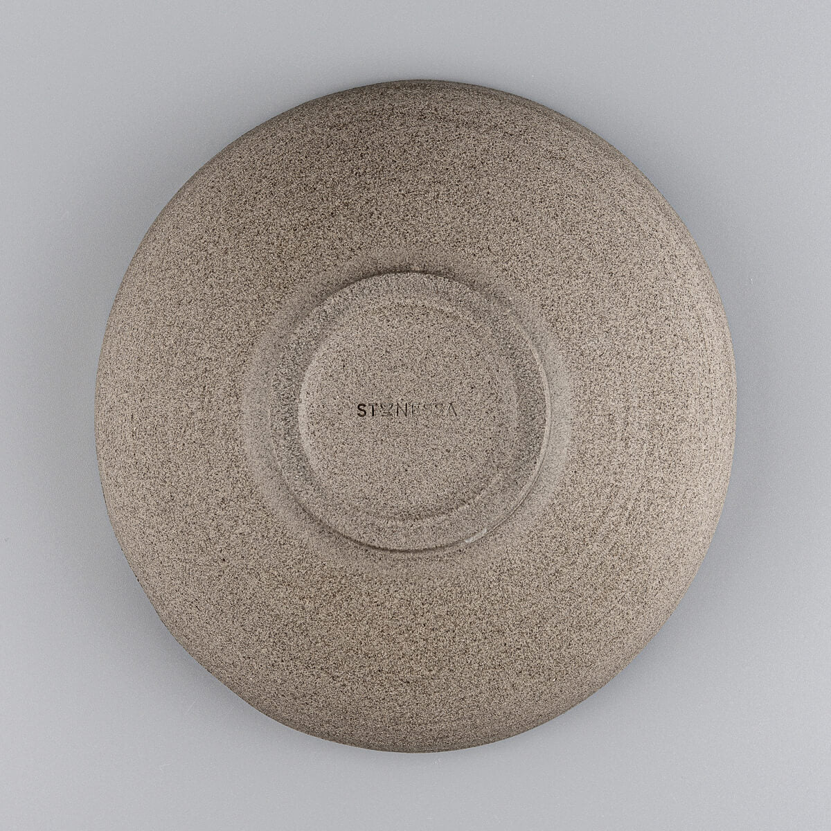 Bottom view of handmade pottery bowl revealing foot ring and unglazed base.