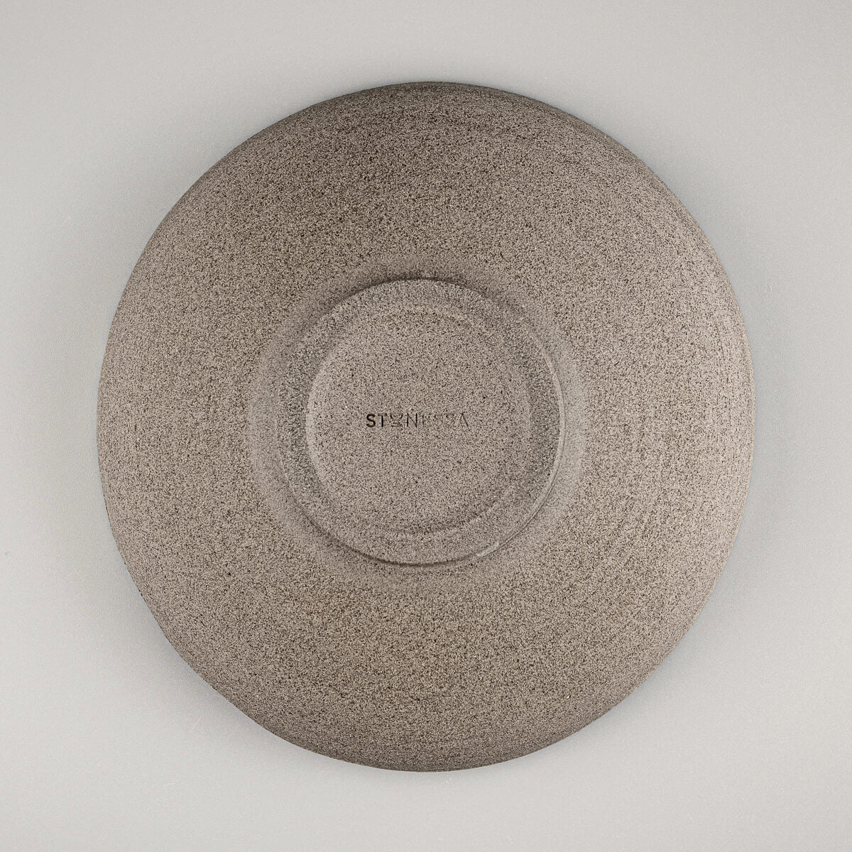 Bottom view of handmade pottery bowl revealing foot ring and unglazed base.