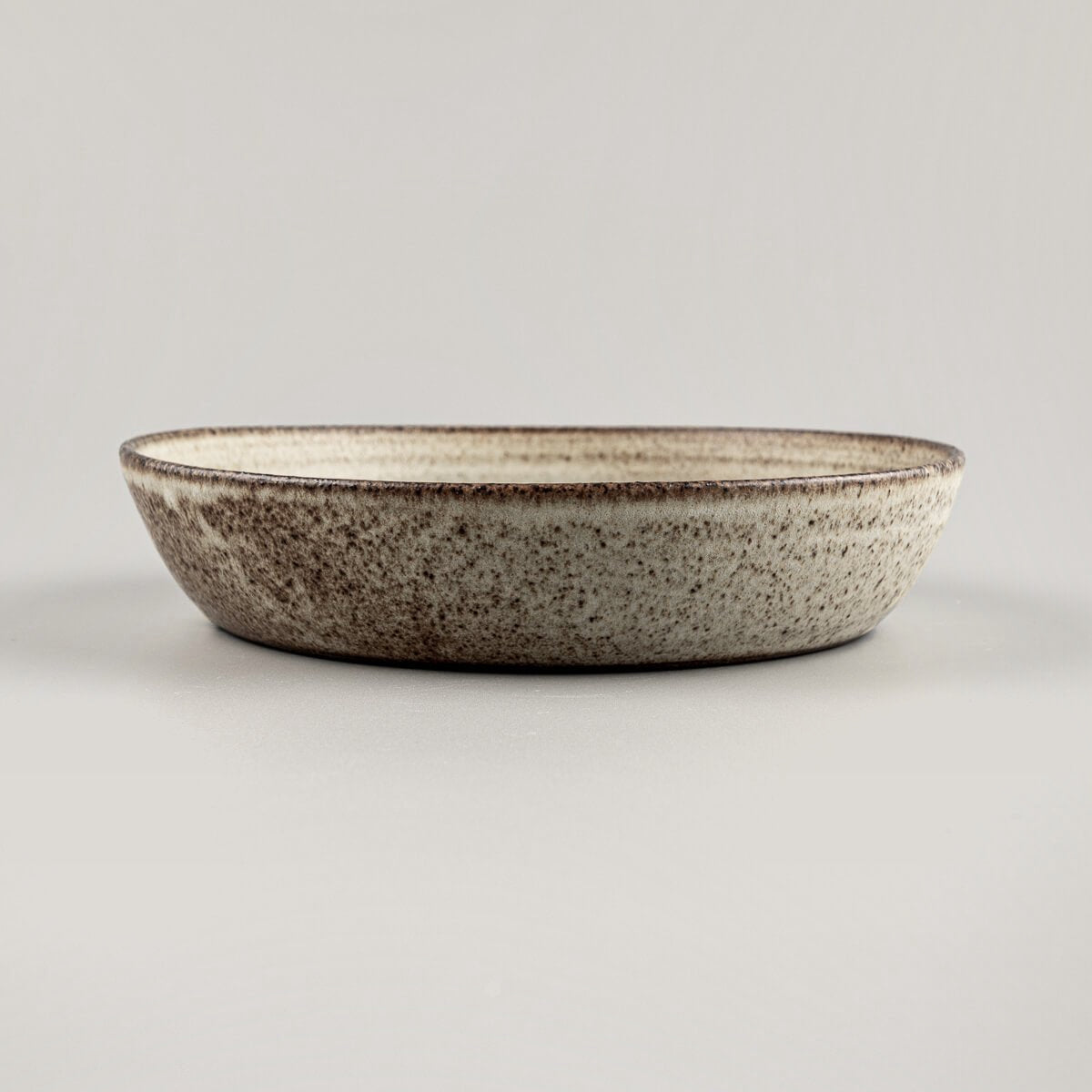 Rustic ceramic plate crafted from stoneware clay with natural texture and handmade finish.