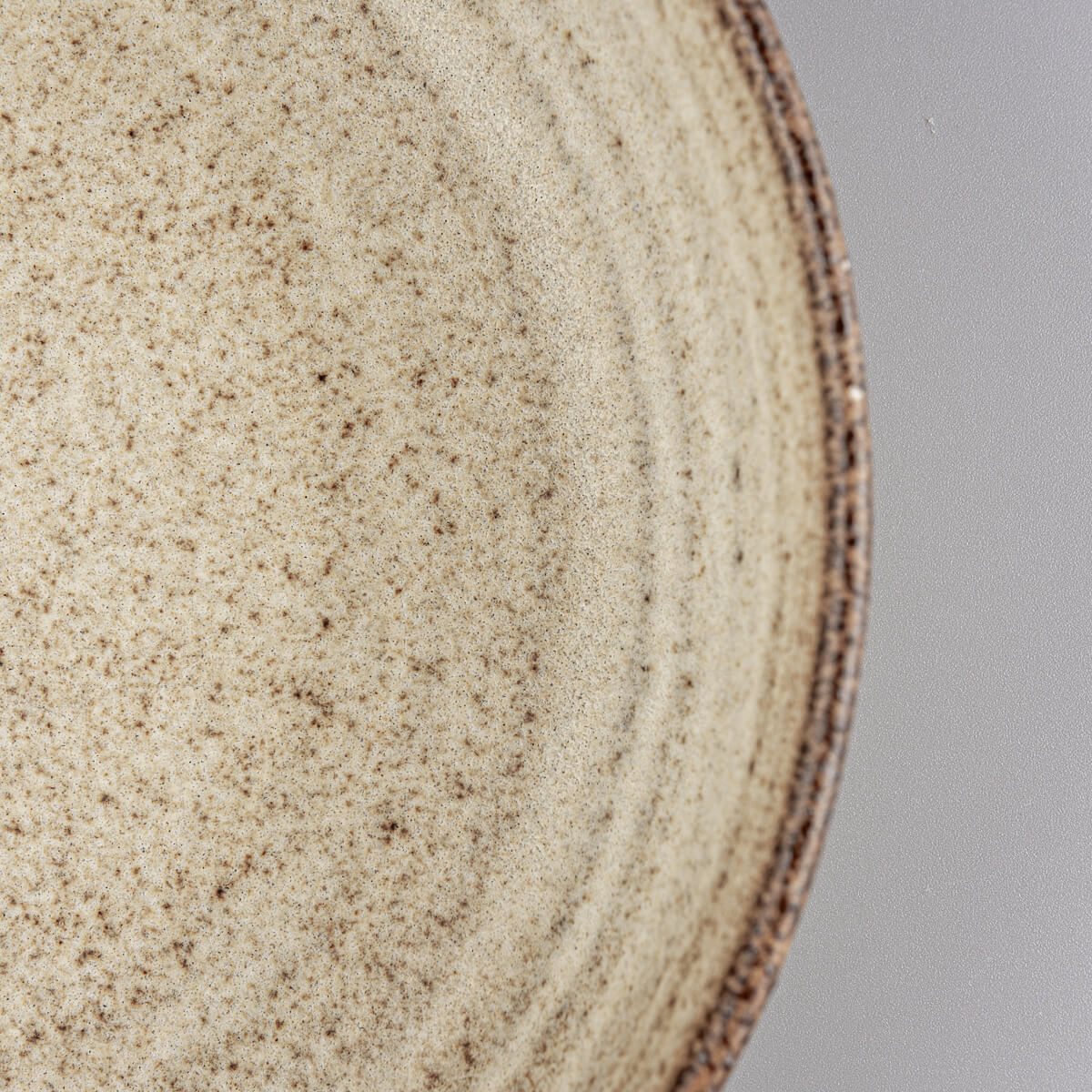 Elevated profile of handmade ceramic dinner plate with warm matte glaze.