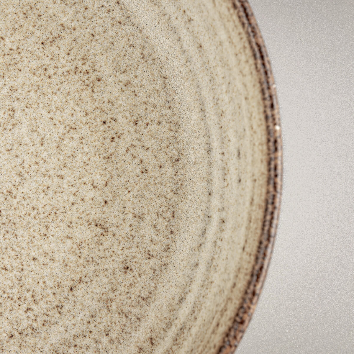 Elevated profile of handmade ceramic dinner plate with warm matte glaze.