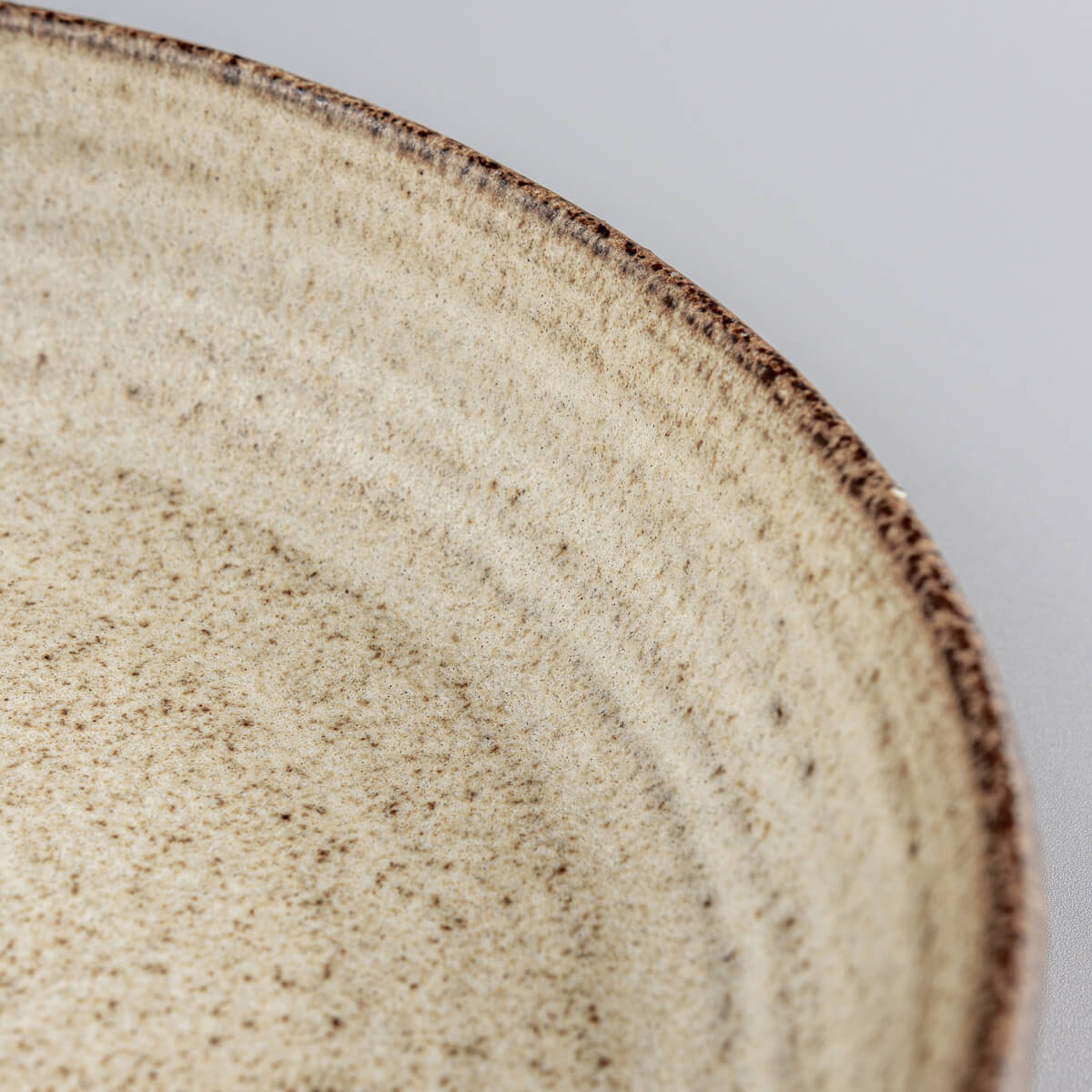 Close-up of ceramic tableware showing handcrafted ridges and textured surface.