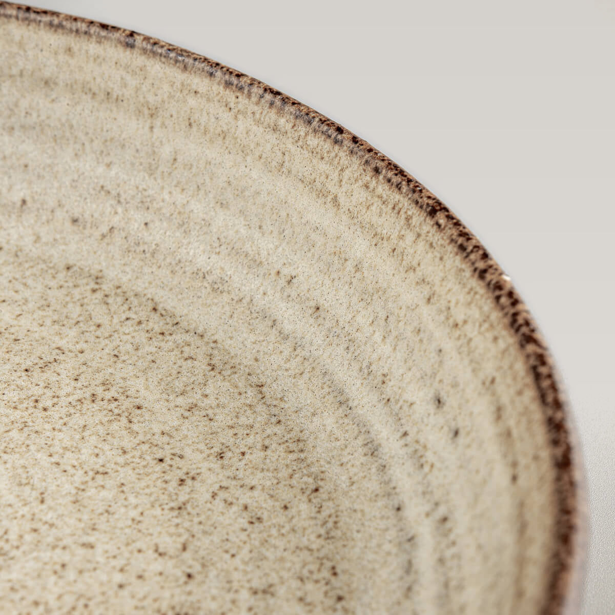 Close-up of ceramic tableware showing handcrafted ridges and textured surface.