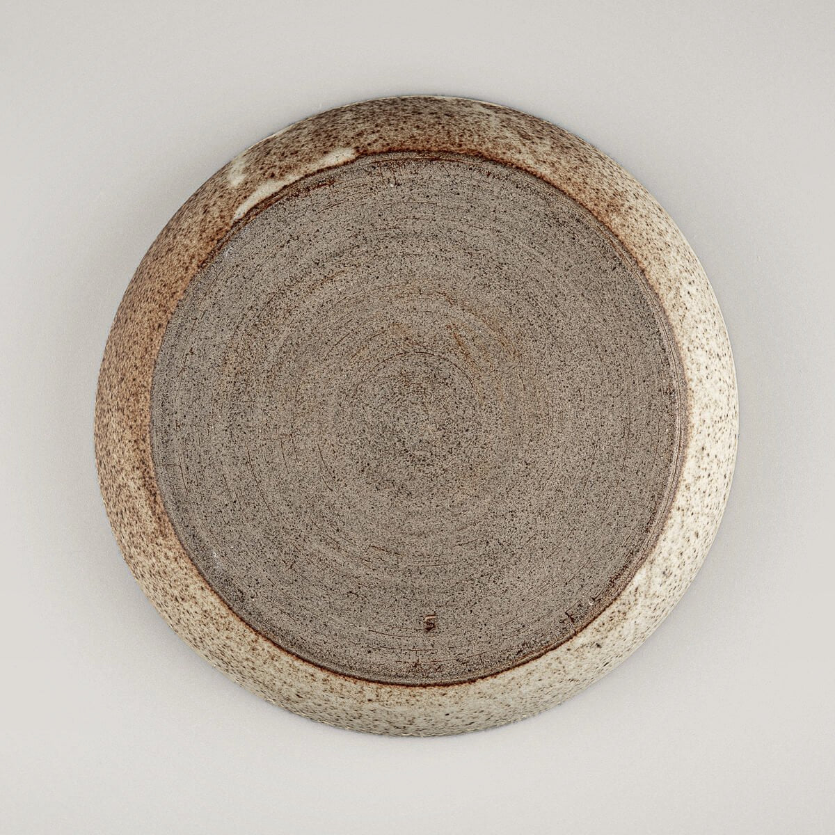 Top view of rustic stoneware dinner plate perfect for culinary presentation and decor.