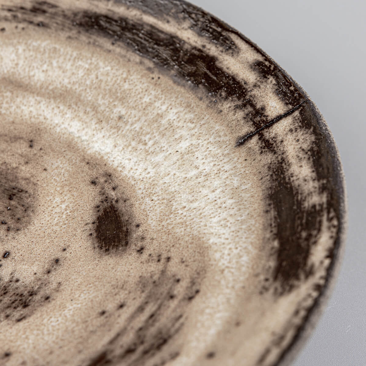 Fine detail of matte glaze texture on artisanal ceramic serving plate.