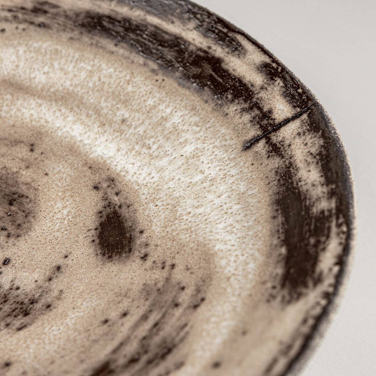 Fine detail of matte glaze texture on artisanal ceramic serving plate.