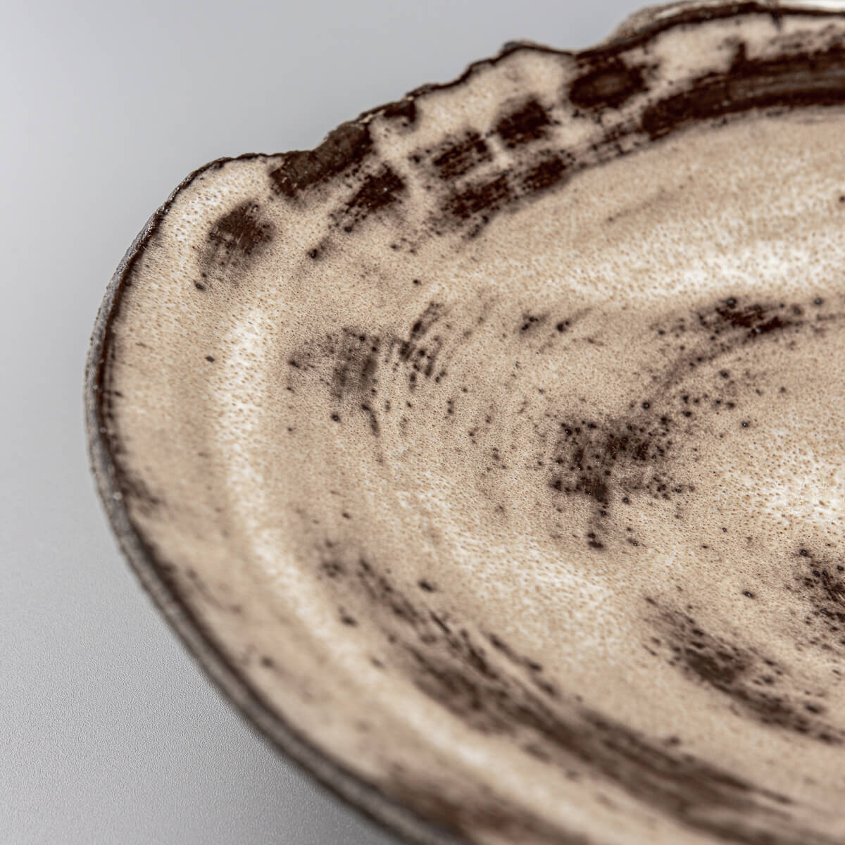 Hand-textured ceramic plate edge showing artistic pottery techniques.