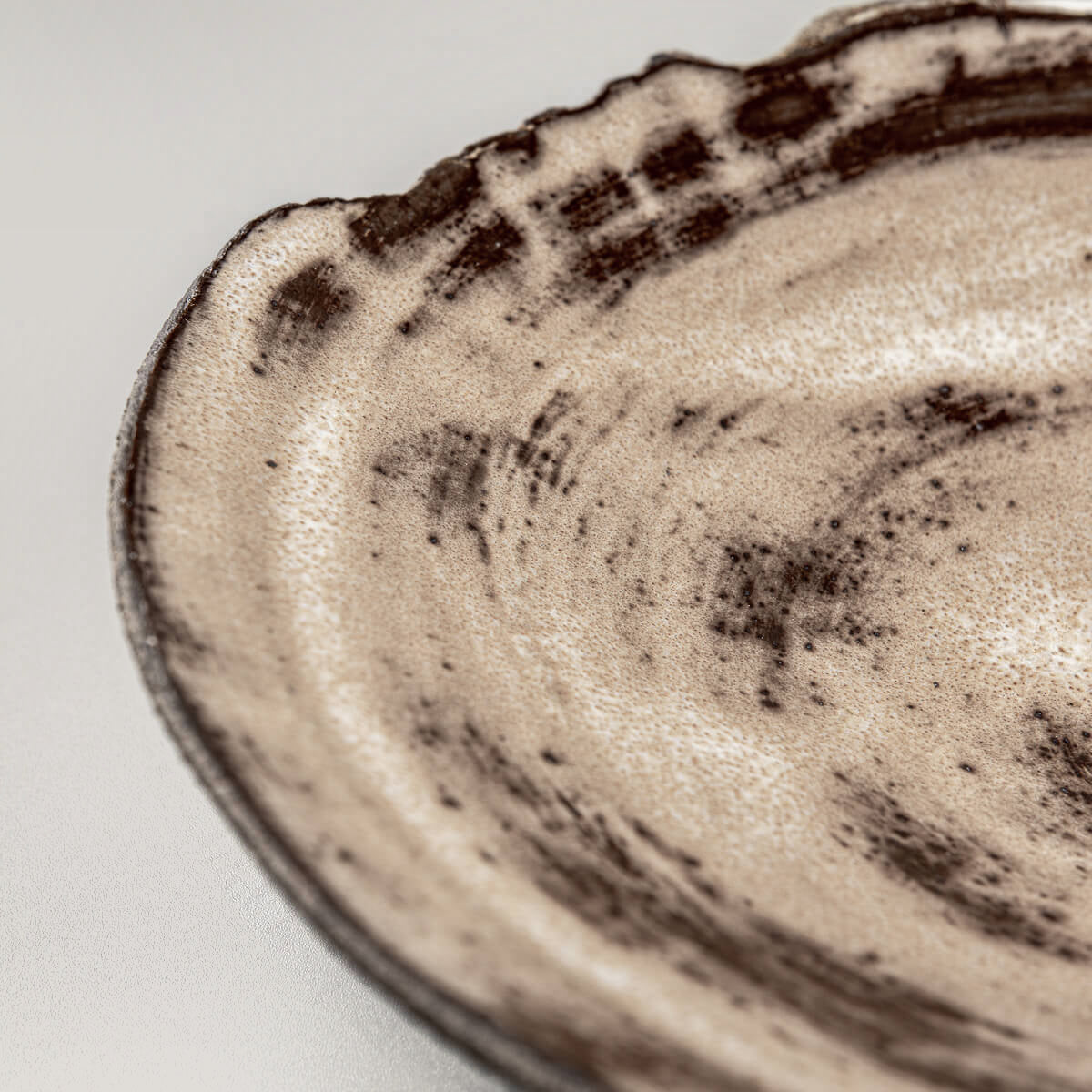 Hand-textured ceramic plate edge showing artistic pottery techniques.