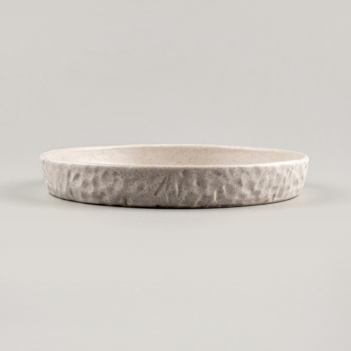 Fine dining stoneware plate in beige, handmade for elegant dessert serving.