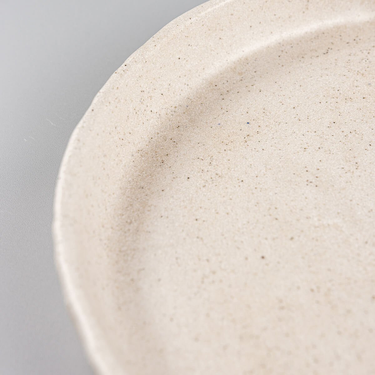 Tactile handcrafted stoneware plate ideal for modern interior dining.