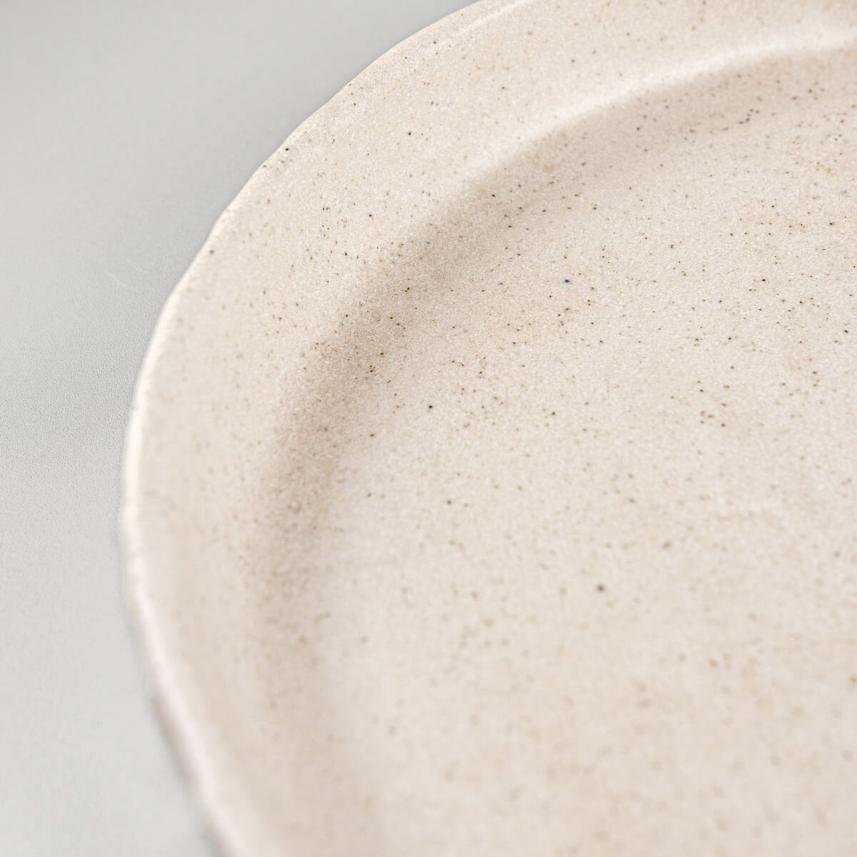 Tactile handcrafted stoneware plate ideal for modern interior dining.