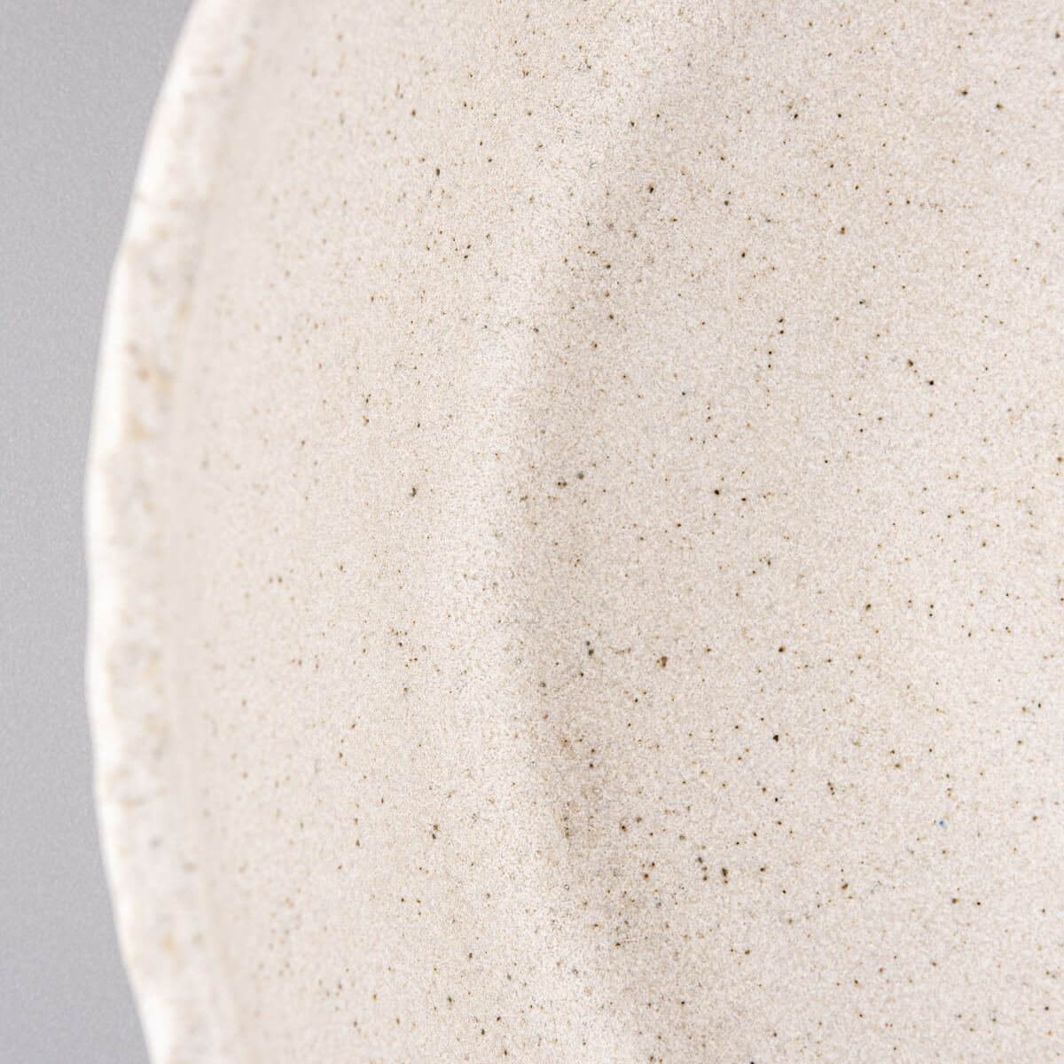 Detail of rustic hand-carved stoneware edge highlighting artisanal craftsmanship and premium quality.
