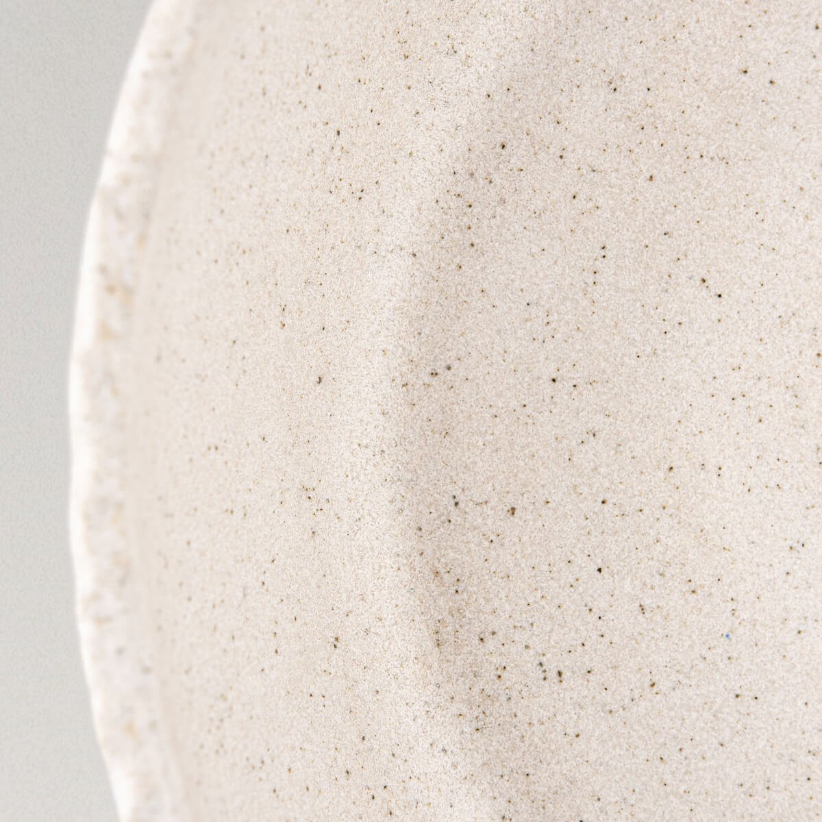 Detail of rustic hand-carved stoneware edge highlighting artisanal craftsmanship and premium quality.