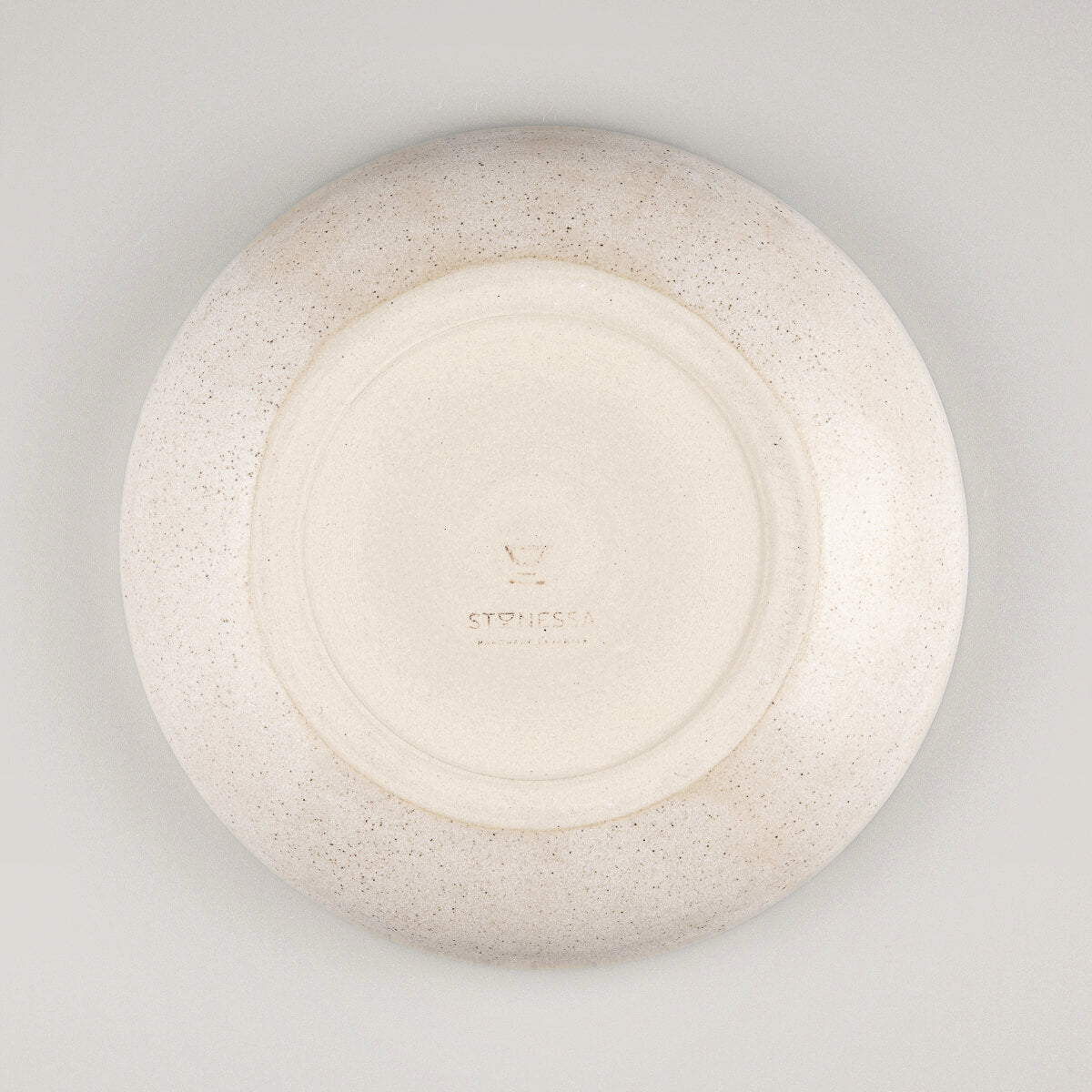 Top-down view of round ceramic dinner plate with minimalist design and handmade charm.