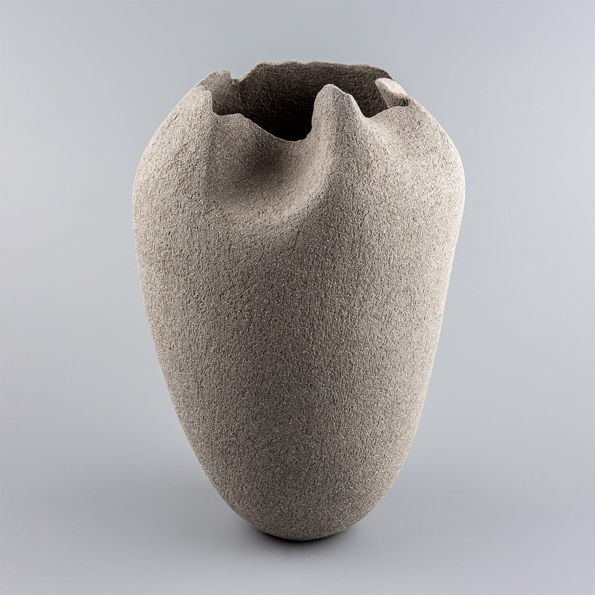 Handmade pottery vase in gray stoneware clay with tulip-inspired design for luxury interiors.
