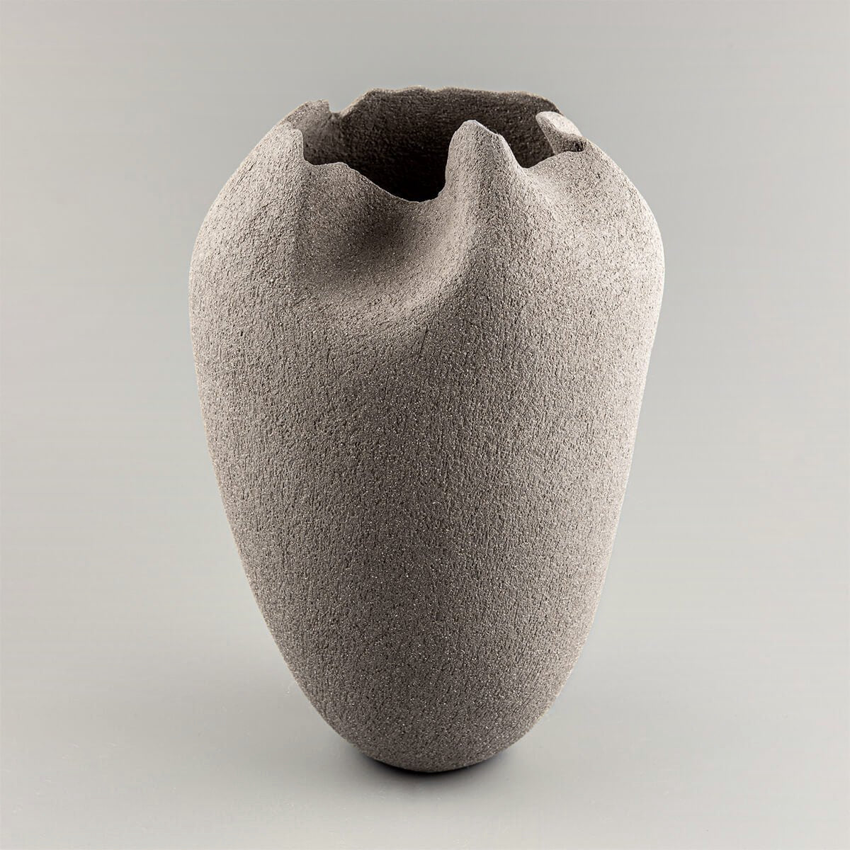 Handmade pottery vase in gray stoneware clay with tulip-inspired design for luxury interiors.