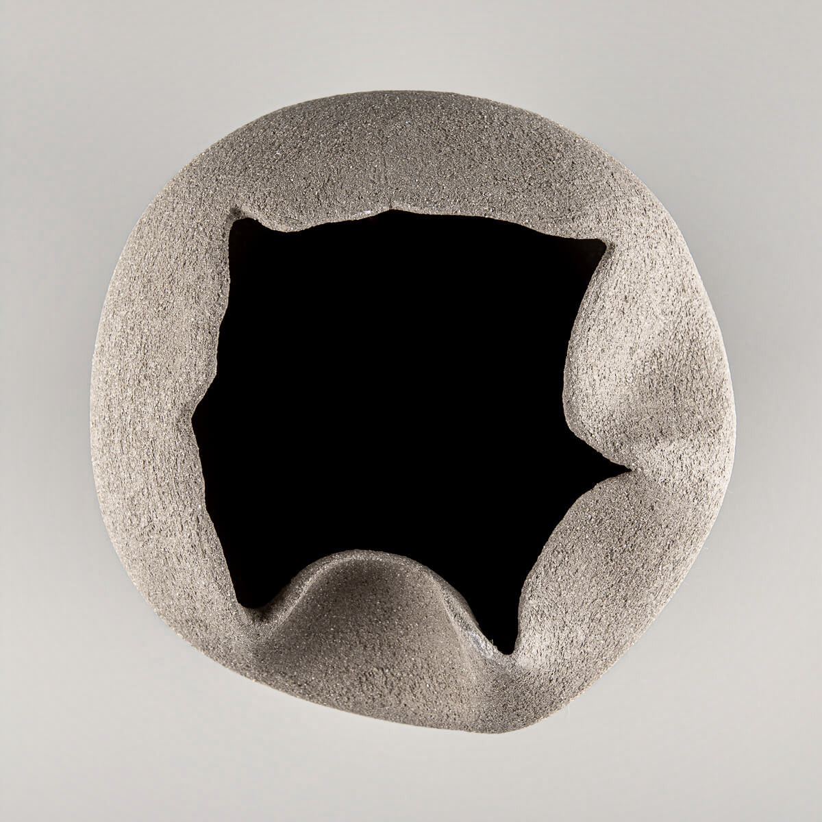 Unglazed sculptural pottery vase with textured surface for boutique hotel and home decor.