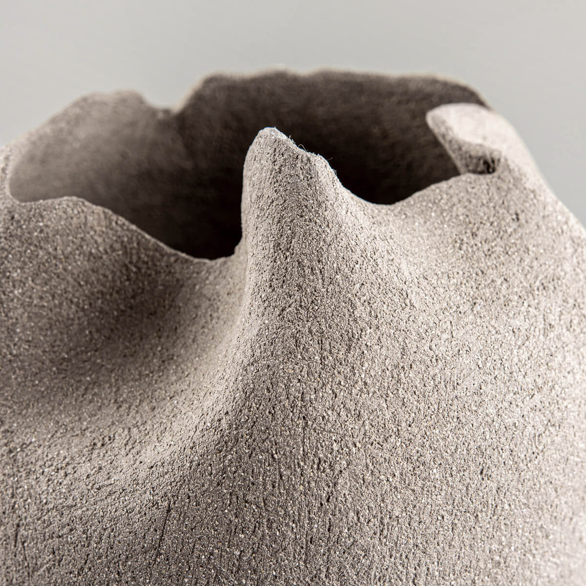 Decorative handmade stoneware vase with organic tulip-like folds for interior design.